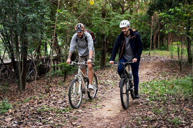 Group of friends ride mountain bike in the forest together