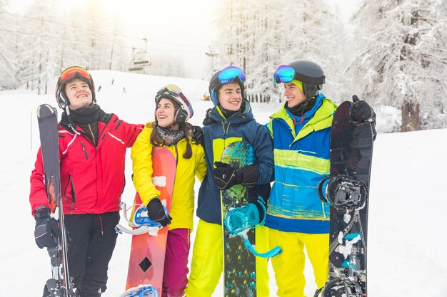 Group of friends on the snow with ski and snowboard 