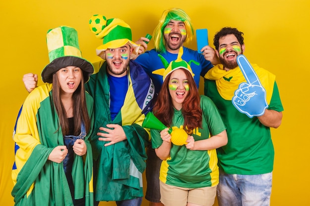 Group of friends soccer fans from Brazil cheering and getting ready to follow a soccer match