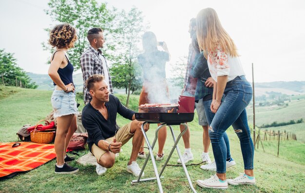 Gruppo di amici che passano il tempo a fare un picnic e un barbecue