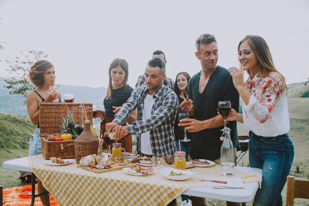 Gruppo di amici che passano il tempo a fare un picnic e un barbecue