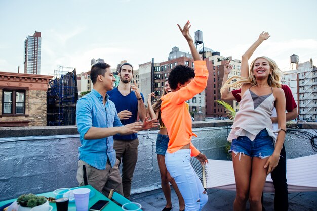 Gruppo di amici che passano insieme tempo su un tetto a new york city, concetto di stile di vita con persone felici