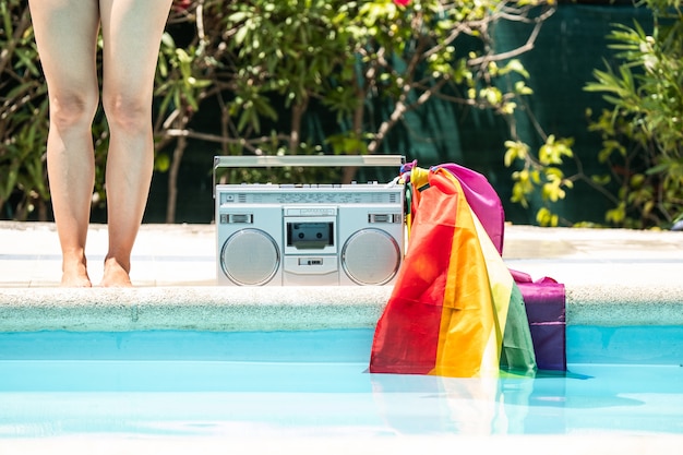 Group of friends sunbathing in the pool with old record player. lgtbi movement