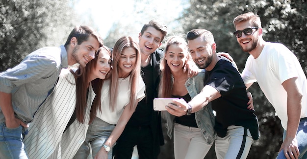 Group of friends takes a selfie on the background of the city Park