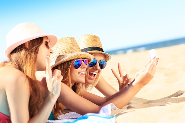 group of friends taking selfie on the beach