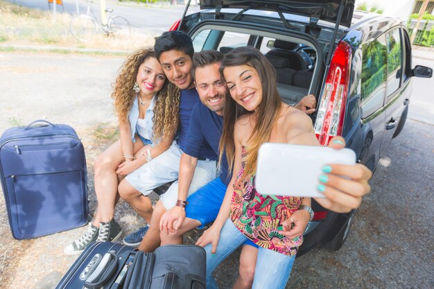 Group of friends taking a selfie before leaving for vacation