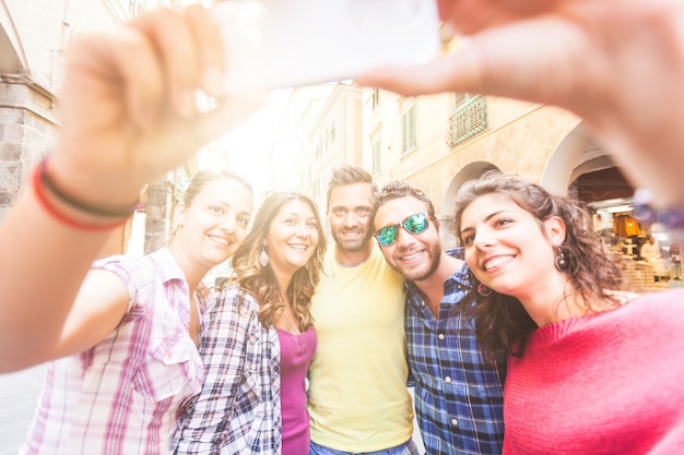 Gruppo di amici che prendono un selfie in città