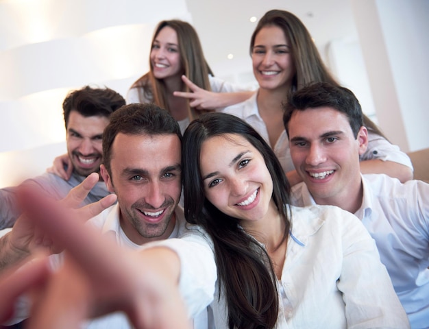 group of friends taking selfie photo with tablet at modern home indoors