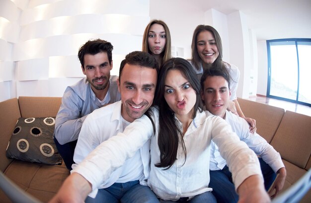 group of friends taking selfie photo with tablet at modern home indoors