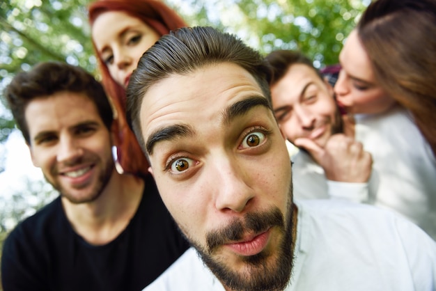 Foto gruppo di amici che assumono selfie in background urbano