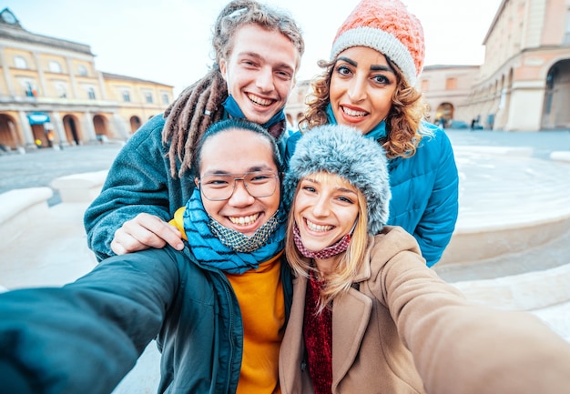 Group of friends taking a selfie wearing face mask