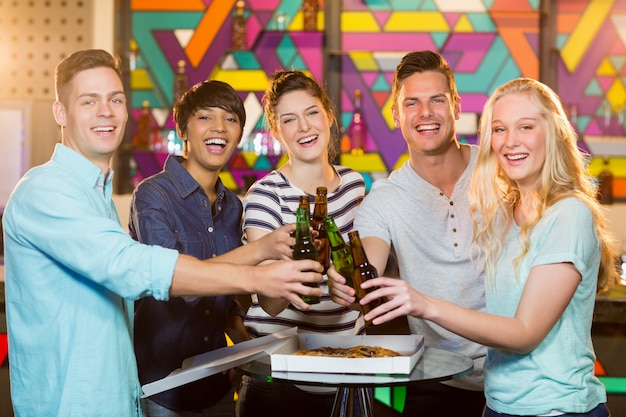Group of friends toasting bottle of beer