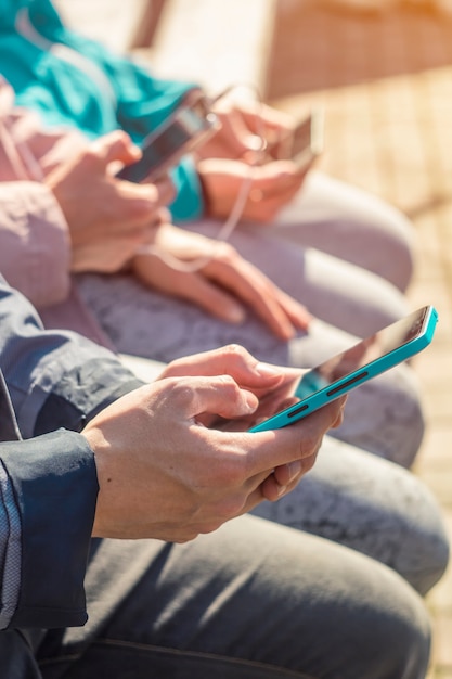 A group of friends use telephones to communicate. Gadgets in the hands of teenagers. 