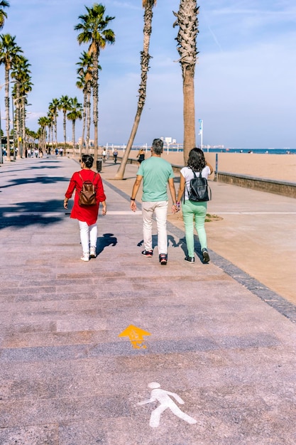 Group of friends walking on boardwalk in tourist area