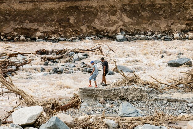 A group of friends walking near a fast flowing river