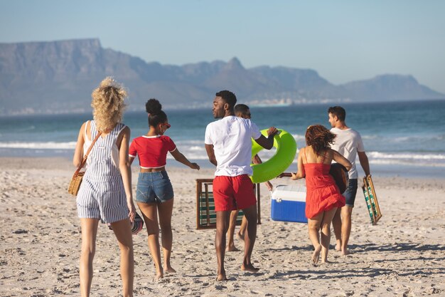 Photo group of friends walking together on the beach