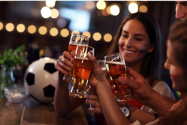 Group of friends watching soccer game in pub