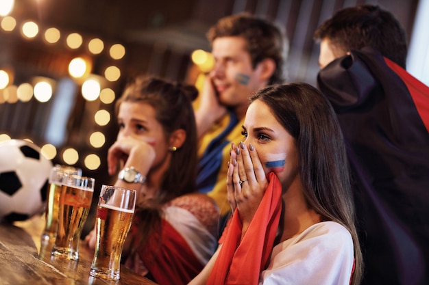 Group of friends watching soccer game in pub