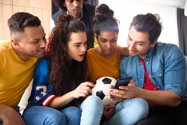 Photo group of friends watching something surprising on the phone