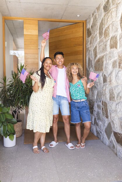 Photo group of friends waving american flags standing at home entrance