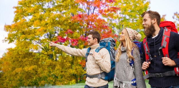 Photo group of friends with backpacks hiking in autumn