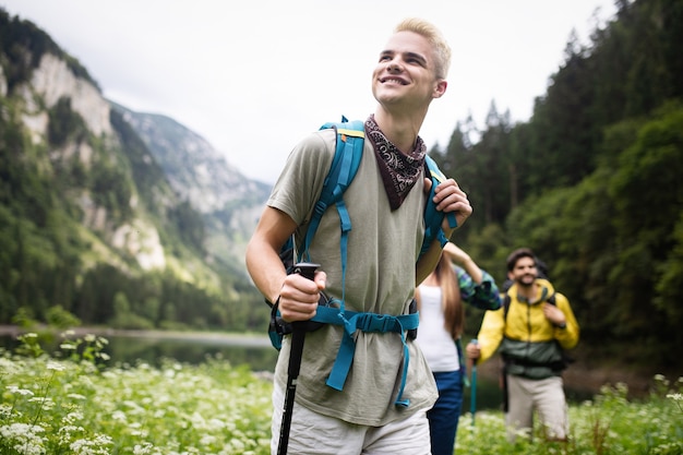 Group of friends with backpacks trekking together in nature