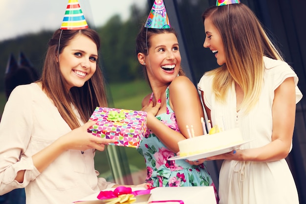 Photo group of friends with cake and presents celebrating birthday