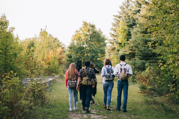 Foto gruppo di amici con i packpacks nella foresta