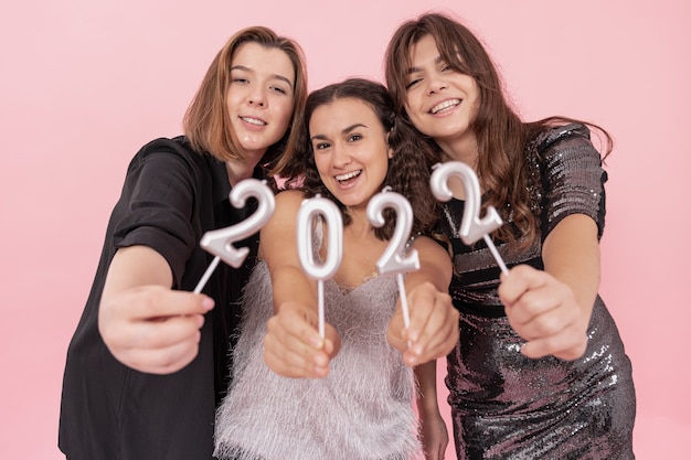 Foto un gruppo di ragazze tiene in mano le candele dei numeri su uno sfondo rosa