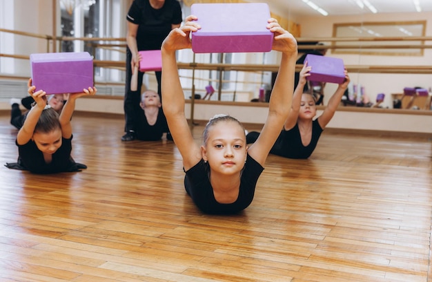 A group of girls doing gymnastics doing gymnastic\
exercises.