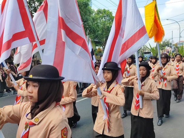 a group of girls march in a parade with flags and flags.