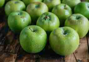 Photo a group of green apples on a wooden table