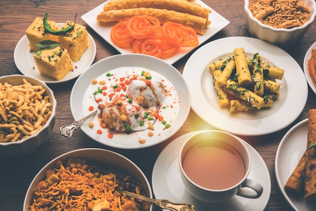 Group of Gujarati snacks like jalebi-fafda, thepla, khaman dhokla, aloo bhujiya, khandvi,khakra, dahi vada, gathiya with hot tea