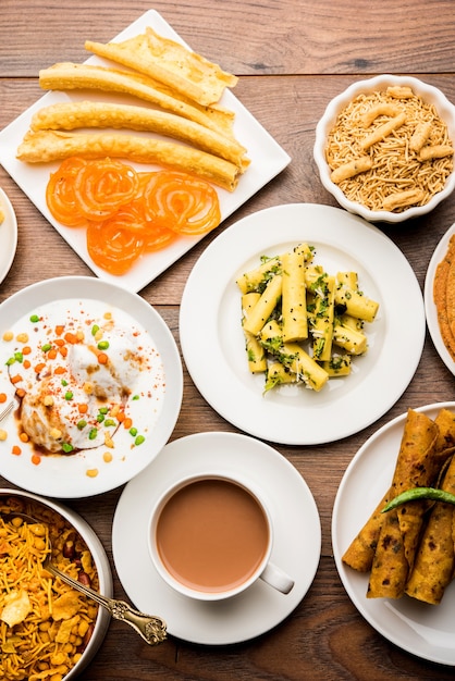 Photo group of gujarati snacks like jalebi-fafda, thepla, khaman dhokla, aloo bhujiya, khandvi,khakra, dahi vada, gathiya with hot tea