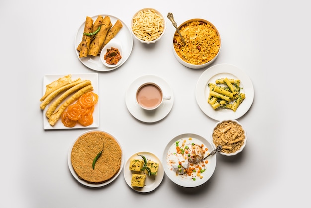 Group of Gujarati snacks like jalebi-fafda, thepla, khaman dhokla, aloo bhujiya, khandvi,khakra, dahi vada, gathiya with hot tea