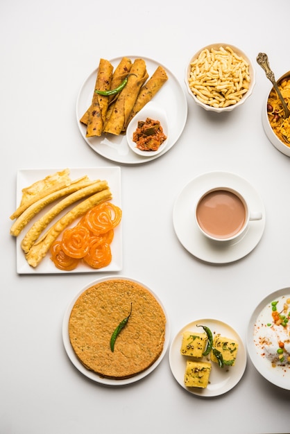 Photo group of gujarati snacks like jalebi-fafda, thepla, khaman dhokla, aloo bhujiya, khandvi,khakra, dahi vada, gathiya with hot tea