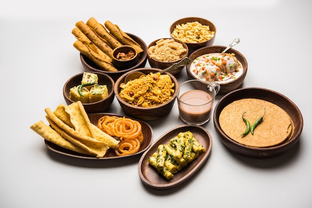 Group of Gujarati snacks like jalebi-fafda, thepla, khaman dhokla, aloo bhujiya, khandvi,khakra, dahi vada, gathiya with hot tea