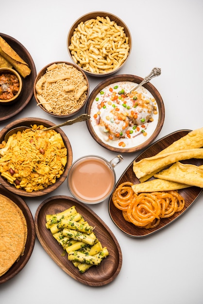 Foto gruppo di snack gujarati come jalebi-fafda, thepla, khaman dhokla, aloo bhujiya, khandvi,khakra, dahi vada, gathiya con tè caldo