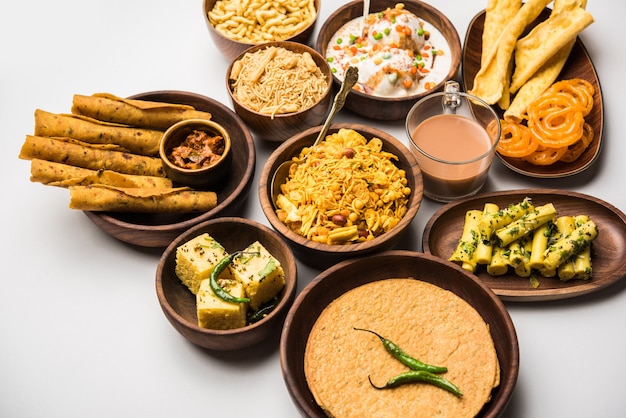 Group of Gujarati snacks like jalebi-fafda, thepla, khaman dhokla, aloo bhujiya, khandvi,khakra, dahi vada, gathiya with hot tea