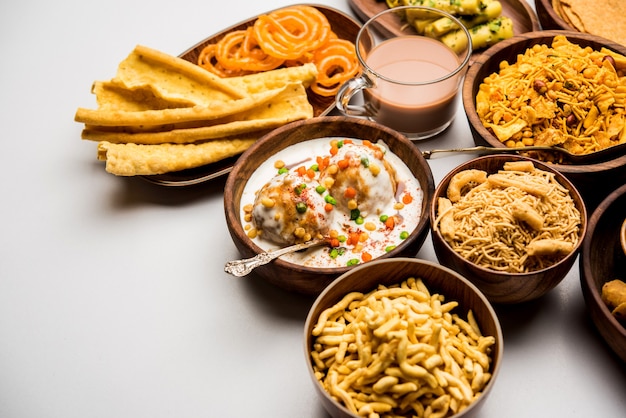 Group of Gujarati snacks like jalebi-fafda, thepla, khaman dhokla, aloo bhujiya, khandvi,khakra, dahi vada, gathiya with hot tea