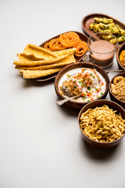 Foto gruppo di snack gujarati come jalebi-fafda, thepla, khaman dhokla, aloo bhujiya, khandvi,khakra, dahi vada, gathiya con tè caldo