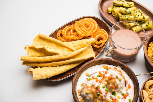 Photo group of gujarati snacks like jalebi-fafda, thepla, khaman dhokla, aloo bhujiya, khandvi,khakra, dahi vada, gathiya with hot tea