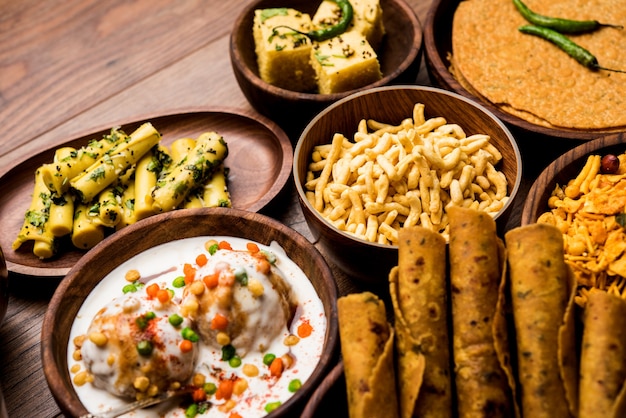 Group of Gujarati snacks like jalebi-fafda, thepla, khaman dhokla, aloo bhujiya, khandvi,khakra, dahi vada, gathiya with hot tea