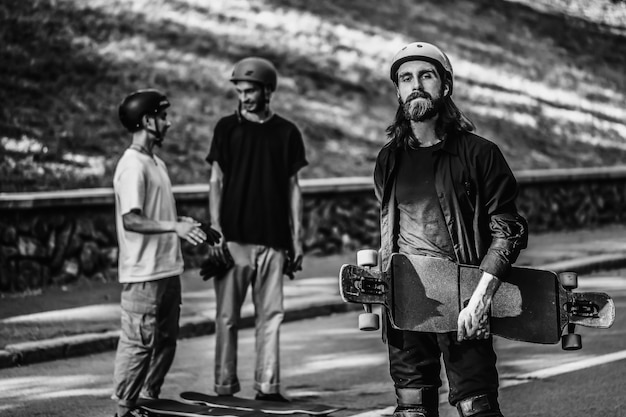 A group of guys ride longboards. Black and white portrait of a skateboarder. High quality photo