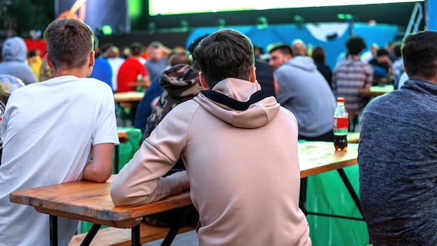 Group of guys sitting at the table and watching football in a public place