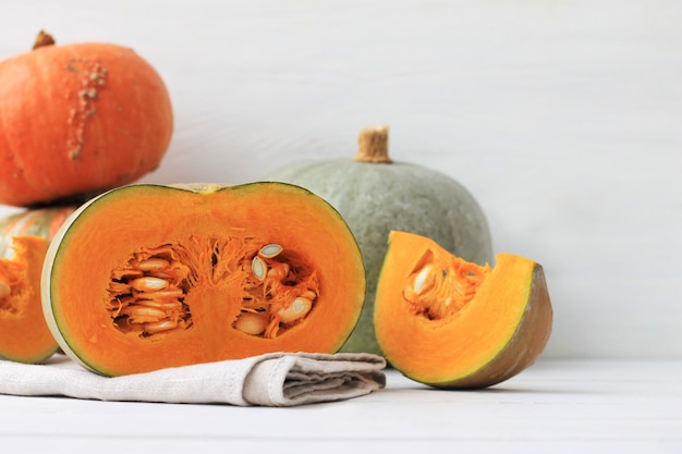 Group of halves and whole pumpkin on light wood