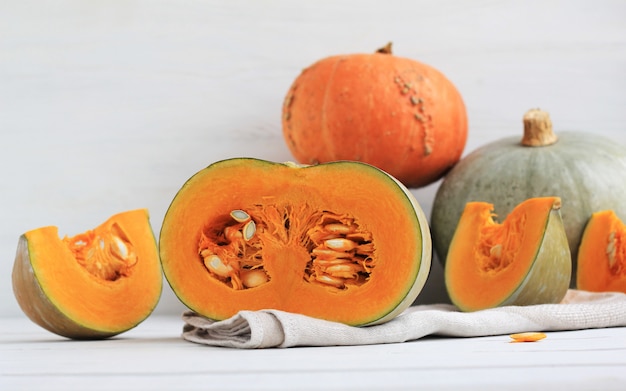 Group of halves and whole pumpkin on light wood