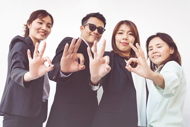 Group of happy business people showing ok gesture 