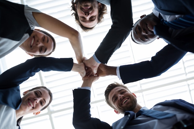 Group of happy businesspeople giving high five to each other