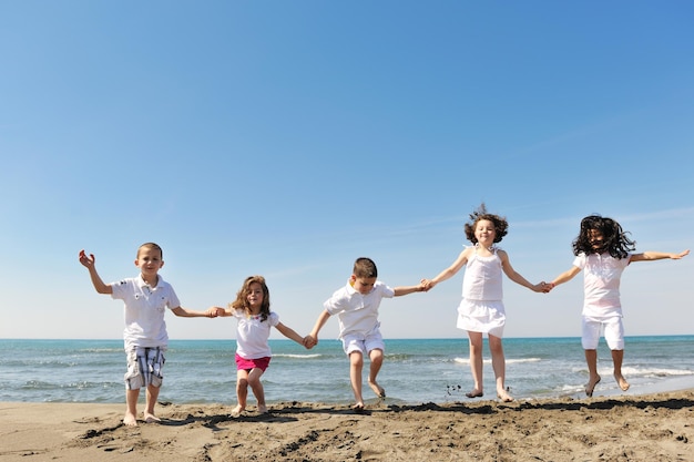 group of happy child on beach who have fun and play games